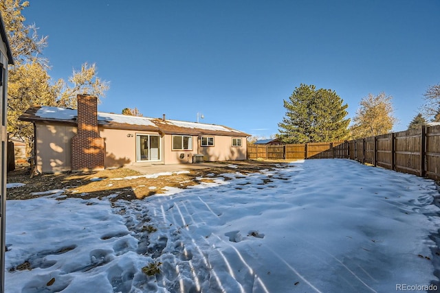 view of snow covered rear of property