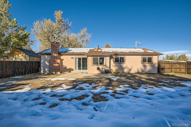 snow covered property featuring central air condition unit and a patio