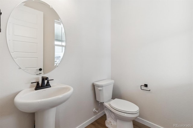 bathroom featuring sink, wood-type flooring, and toilet