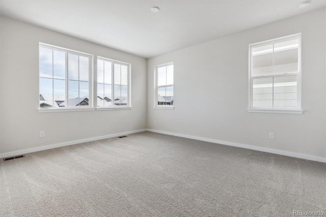 carpeted spare room featuring plenty of natural light