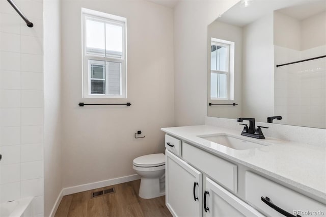 full bathroom with vanity, toilet, wood-type flooring, and tiled shower / bath