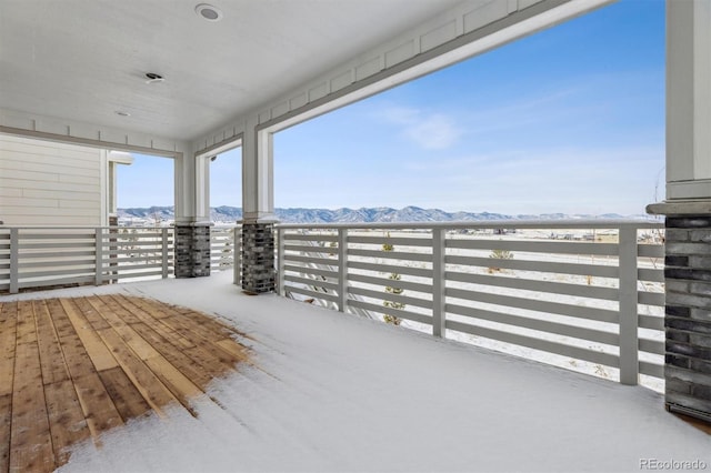 snow covered patio featuring a mountain view