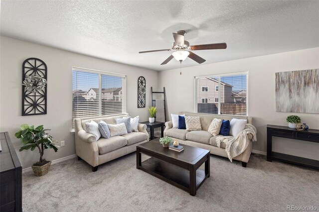 carpeted living room with ceiling fan and a textured ceiling