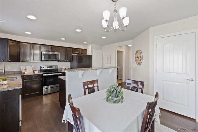 dining space with dark hardwood / wood-style flooring, sink, and a chandelier