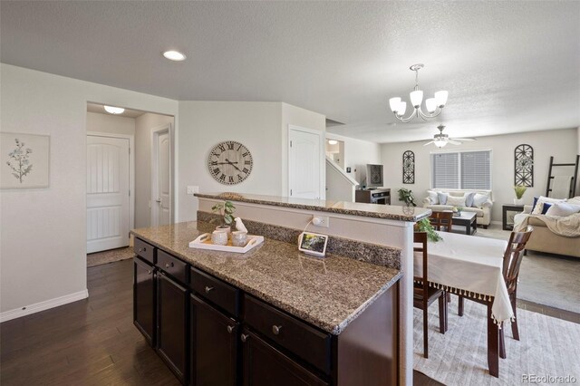 kitchen with dark brown cabinets, a center island, and dark hardwood / wood-style floors