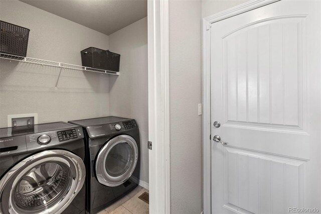 washroom featuring washer and clothes dryer and light tile patterned floors