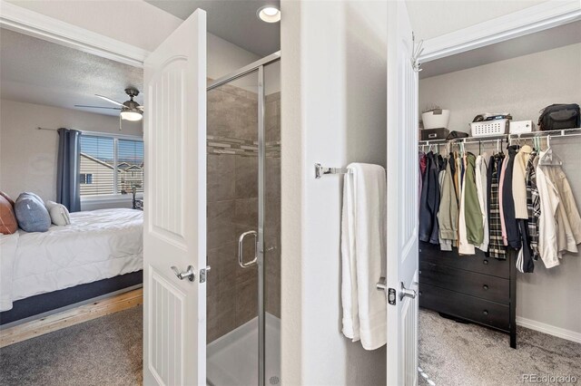 bathroom featuring ceiling fan and a shower with shower door