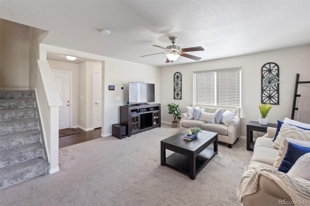 carpeted living room with ceiling fan and a textured ceiling