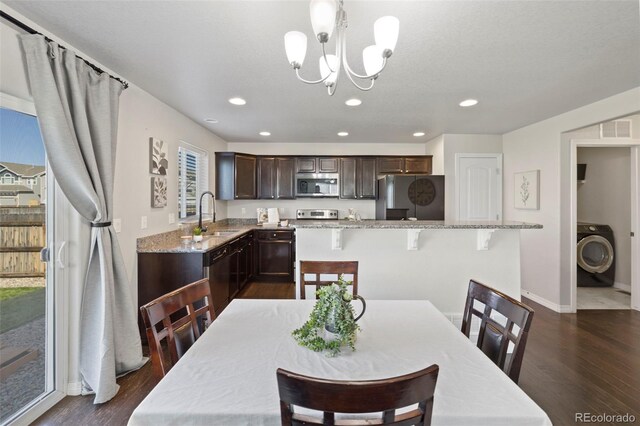 dining area featuring washer / dryer, dark hardwood / wood-style floors, and a healthy amount of sunlight