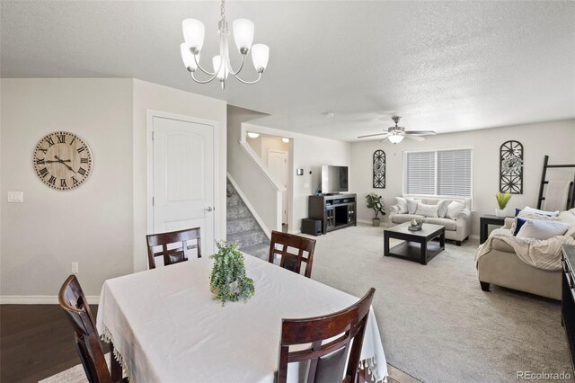 carpeted dining space featuring a textured ceiling and ceiling fan with notable chandelier