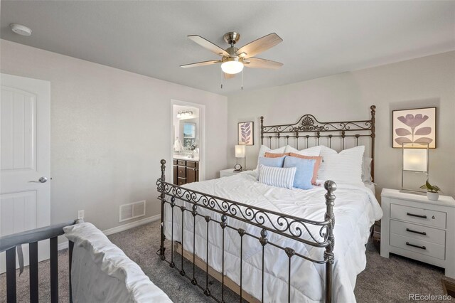 bedroom featuring ceiling fan, ensuite bathroom, and dark colored carpet