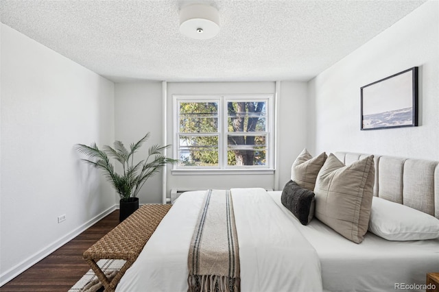 bedroom with dark hardwood / wood-style flooring and a textured ceiling