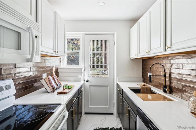 kitchen featuring tasteful backsplash, sink, white cabinets, and white appliances