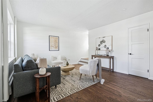 living area featuring a textured ceiling, dark hardwood / wood-style floors, and a wealth of natural light