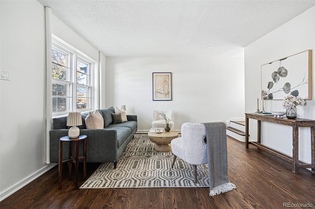 living room with dark wood-type flooring and a textured ceiling