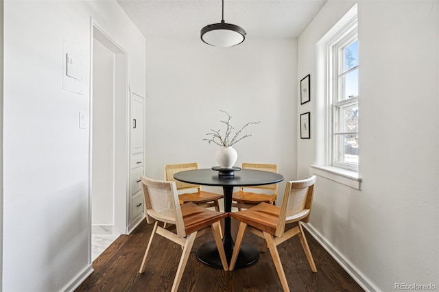 dining area with dark wood-type flooring and a wealth of natural light