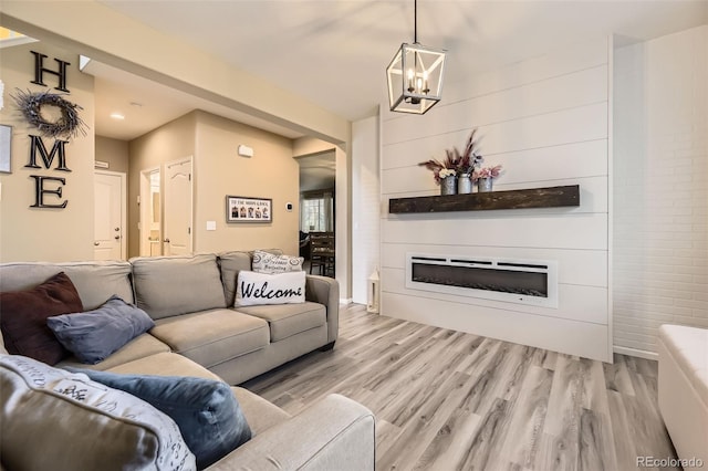 26072 E Fremont Pl, Aurora, CO 80016 - living area featuring a glass covered fireplace, light wood finished floors, a chandelier, and recessed lighting