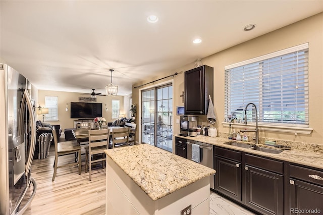 26072 E Fremont Pl, Aurora, CO 80016 - kitchen featuring stainless steel appliances, open floor plan, a kitchen island, light stone countertops, and ceiling fan