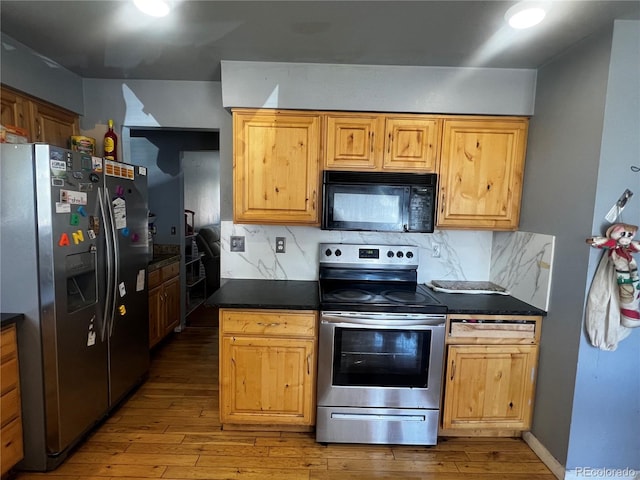 5129 Chandler Way, Denver, CO 80239 - kitchen with stainless steel appliances, dark countertops, hardwood / wood-style flooring, and decorative backsplash