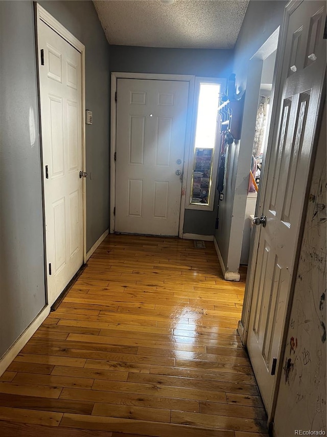 5129 Chandler Way, Denver, CO 80239 - corridor featuring light wood finished floors, a textured ceiling, and baseboards