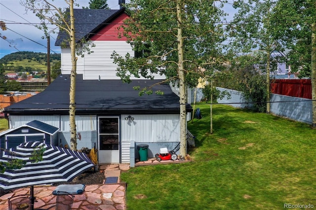 rear view of house featuring a yard