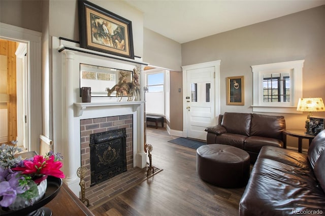 living room with a fireplace and dark wood-type flooring