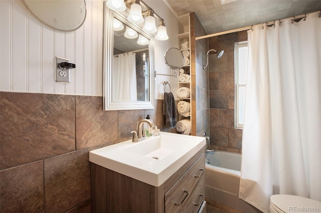 full bathroom with vanity, shower / bath combination with curtain, tile walls, and toilet