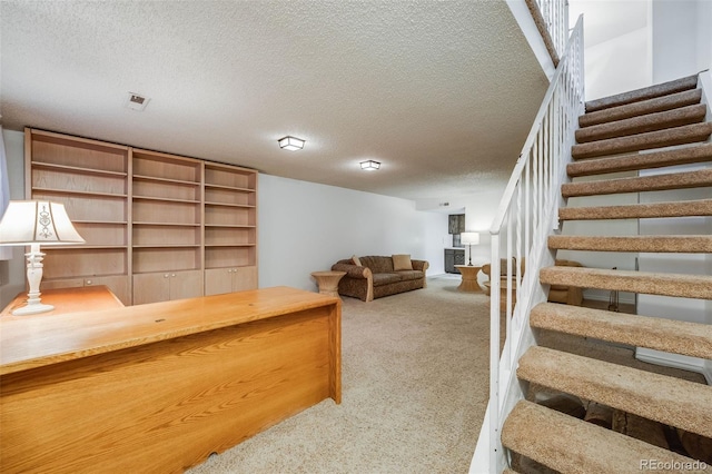 carpeted home office featuring a textured ceiling