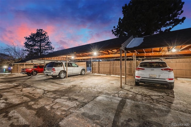 parking at dusk featuring a carport