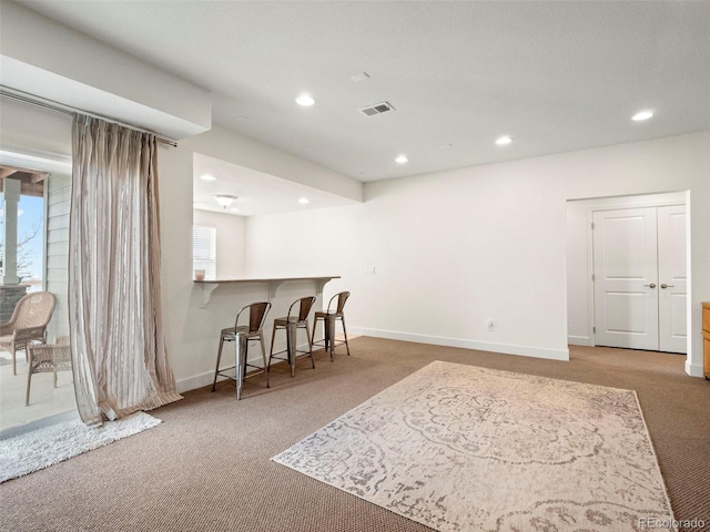 kitchen with carpet floors, recessed lighting, a kitchen breakfast bar, baseboards, and a peninsula