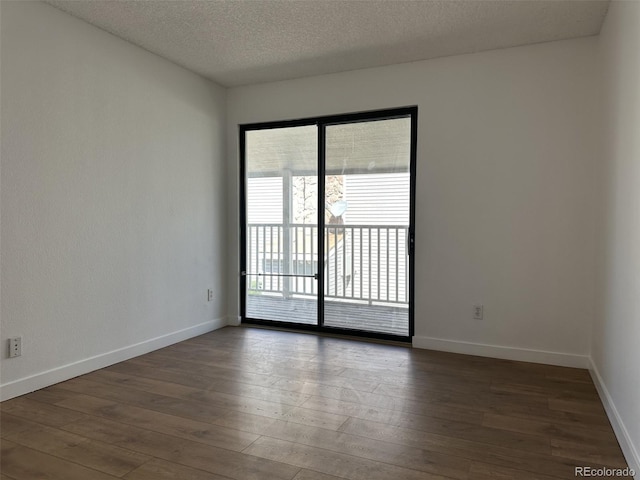 unfurnished room featuring hardwood / wood-style flooring, a textured ceiling, and baseboards