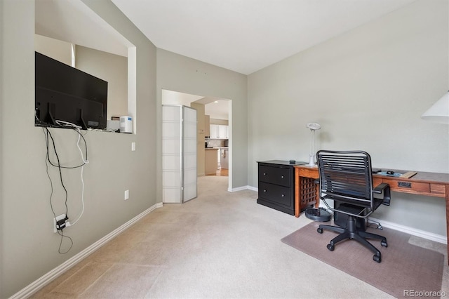home office with baseboards and light carpet