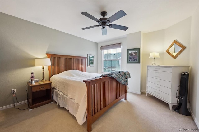 bedroom featuring light colored carpet, baseboards, and ceiling fan