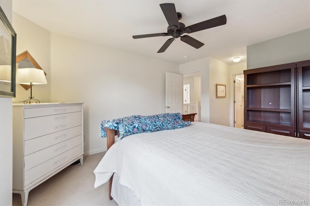 bedroom with ceiling fan, light carpet, and baseboards
