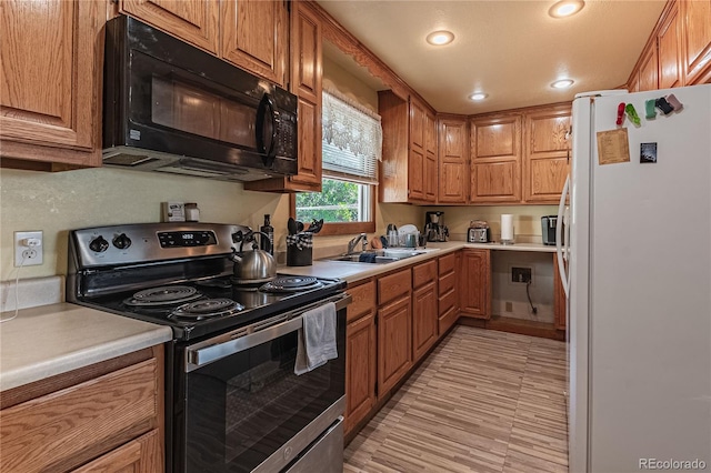 kitchen featuring sink, stainless steel electric range, and white refrigerator