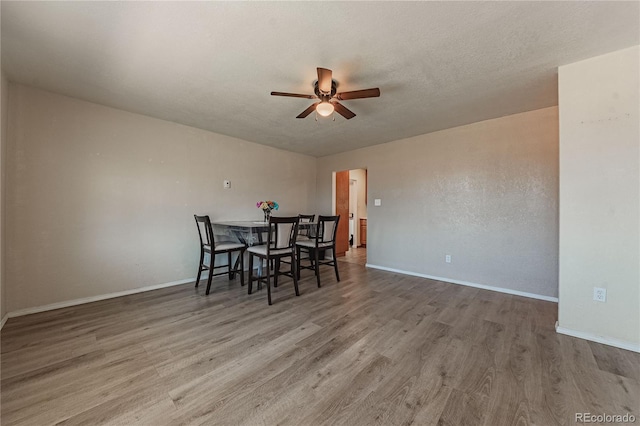 unfurnished dining area with a textured ceiling, ceiling fan, and hardwood / wood-style flooring