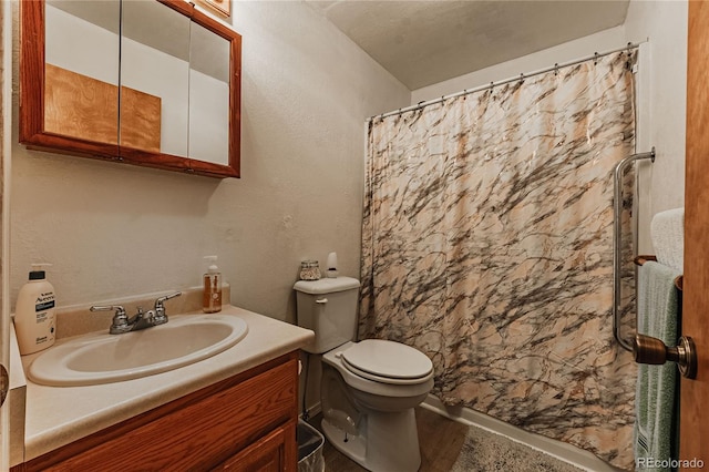 bathroom featuring vanity, toilet, and curtained shower