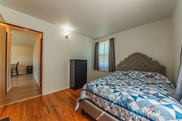 bedroom with wood-type flooring and lofted ceiling