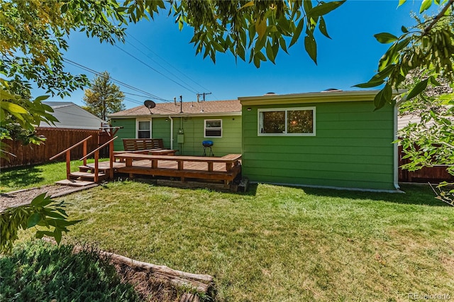 back of property featuring a deck and a yard