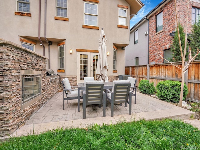 view of patio / terrace with fence, french doors, and exterior kitchen