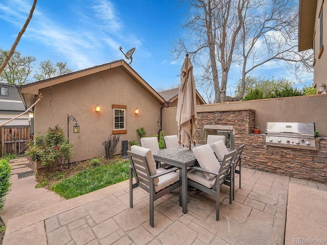view of patio / terrace with area for grilling, exterior kitchen, fence, and outdoor dining space