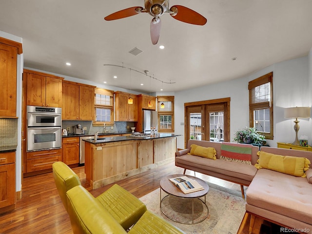 living room with recessed lighting, ceiling fan, light wood finished floors, and visible vents