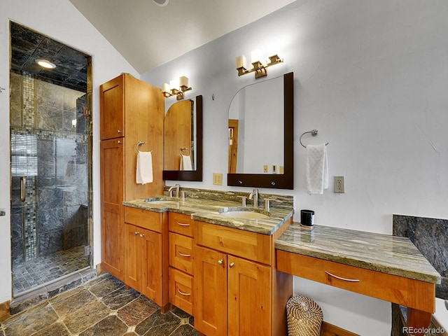 full bathroom featuring a sink, double vanity, stone finish floor, lofted ceiling, and a stall shower
