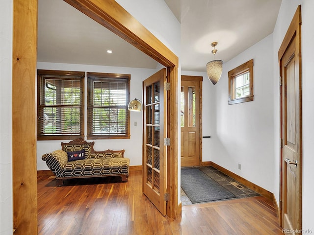 foyer with baseboards and wood-type flooring