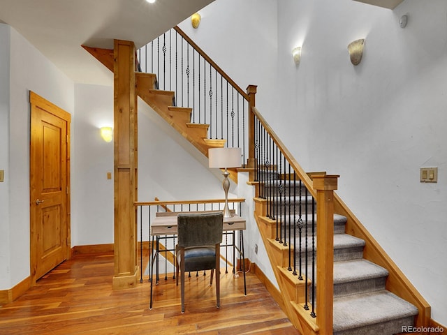 staircase featuring baseboards and wood finished floors