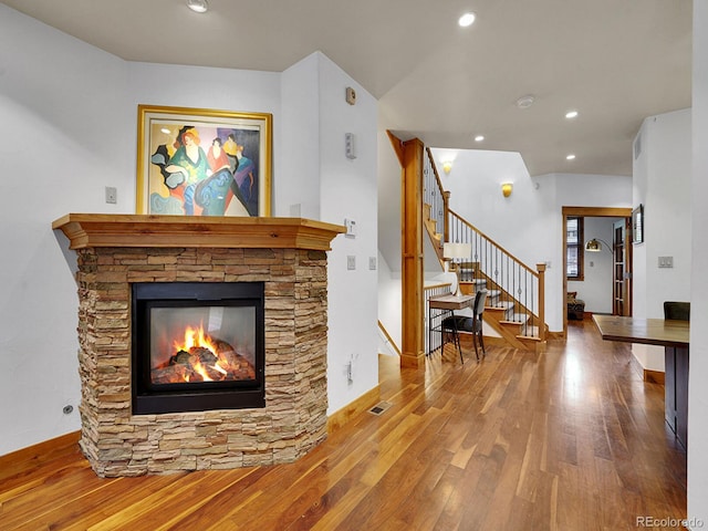 living area with visible vents, wood finished floors, a fireplace, stairway, and recessed lighting