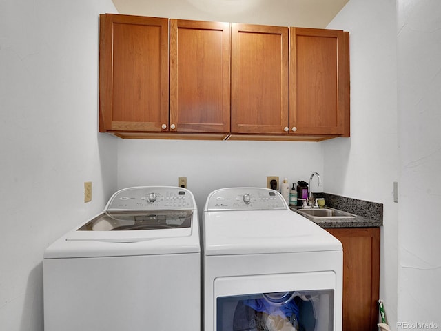 washroom with washing machine and clothes dryer, a sink, and cabinet space