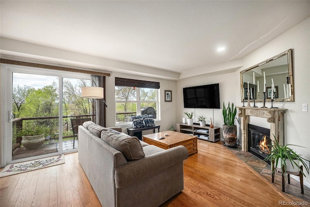 living room with a fireplace with flush hearth, wood-type flooring, and recessed lighting