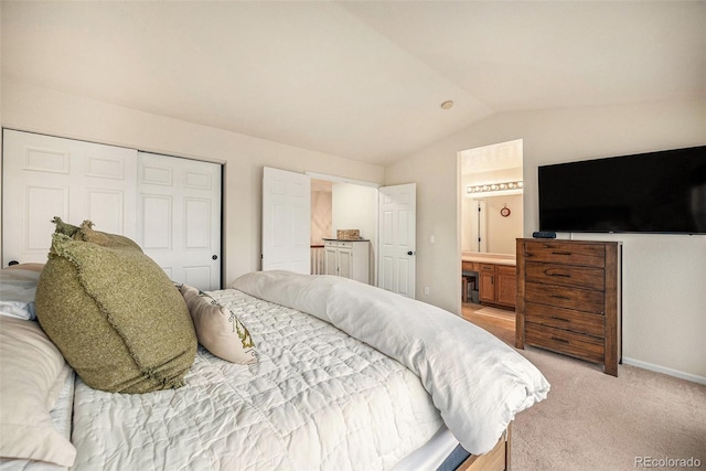 bedroom featuring a closet, light carpet, baseboards, connected bathroom, and vaulted ceiling