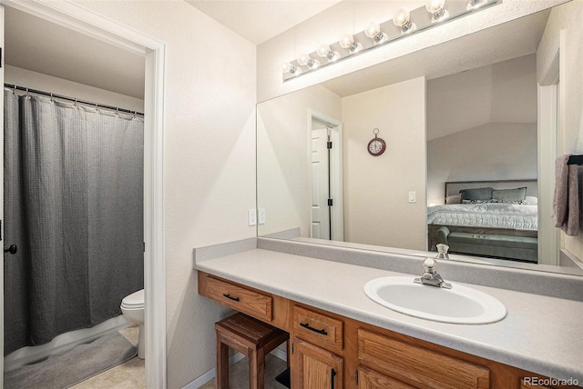 ensuite bathroom with ensuite bathroom, tile patterned flooring, toilet, and vanity
